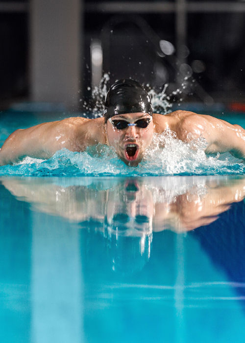 Young male swimmer swimming the butterfly stroke in a pool